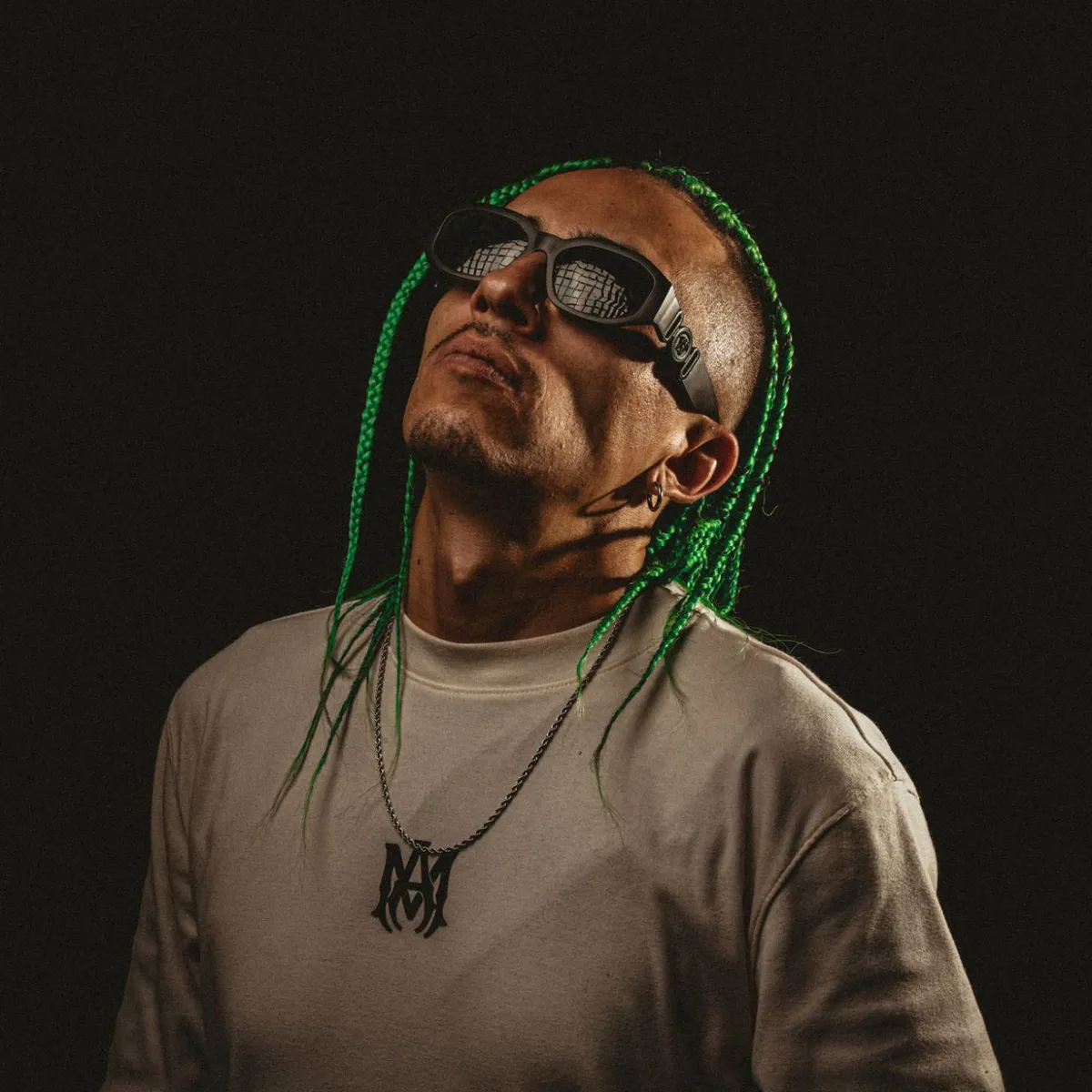 Retrato de SANTO con gafas oscuras y trenzas verdes